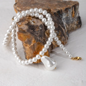 Collana con ciondolo in perla barocca e chiusura dorata su pietra marrone naturale