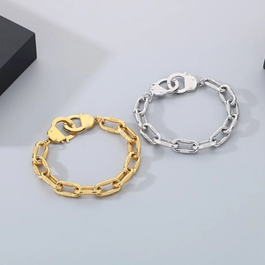 Detail of gold and silver handcuffs-shaped chain bracelets with OT buckle design