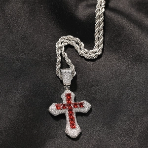 Macro shot of hip hop cross pendant with red gemstones and white zircon in rope chain