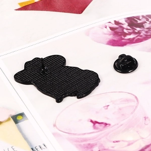 Detailed view of the black enamel cat brooch back with metal texture and rubber clutch