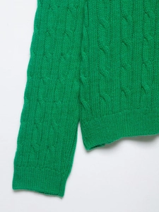 Detail of Kelly Green cable-knit sweater showing premium textured weave and ribbed cuffs