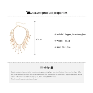 Detail view of gold tassel necklace with rhinestones and glass charms specs
