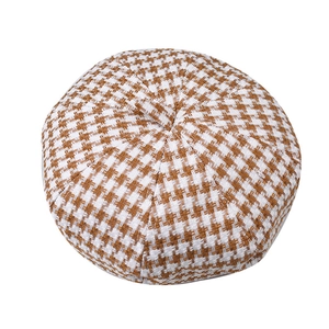 Top view of brown and white houndstooth beret hat showing texture and stem detail