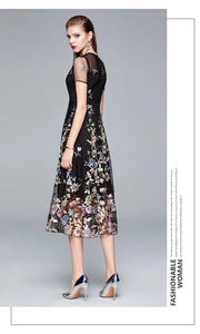 Detailed view of intricate colorful floral embroidery on elegant black mesh dress