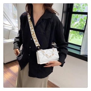 White quilted crossbody bag with decorative metal chain and wide abstract patterned strap