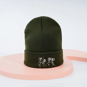Détail de la broderie squelette blanc sur un bonnet en maille vert olive à revers