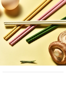 Detail showing non-slip tips of colorful silicone kids chopsticks on a warm background