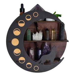Detail of a dark wood moon shelf with a wolf silhouette design for crystal display