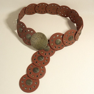 Detail of vintage Baroque style wide brown belt with engraved round metal buckle