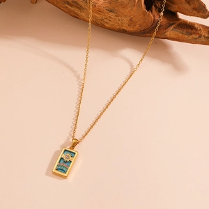 Gold stainless steel tarot necklace featuring sun and rainbow pendant on wooden prop