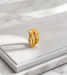 Detail of gold-plated rings featuring engraved star patterns and small inset crystals