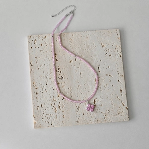 Detail of S925 sterling silver necklace with pink beads and a delicate flower pendant