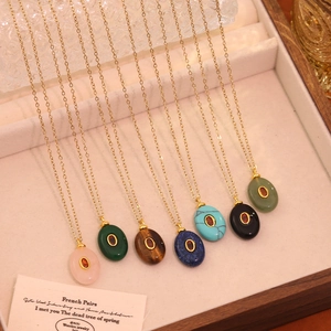 Macro view of French retro oval natural stone pendants in seven colors on golden chains