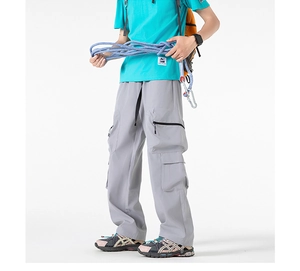 Dettaglio dei pantaloni cargo grigi con tasche laterali con zip e cinturino utile