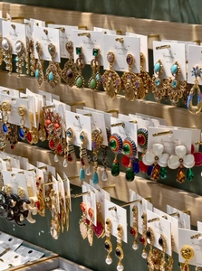 Detail view of vintage enamel flower earrings displayed on branded jewelry cards