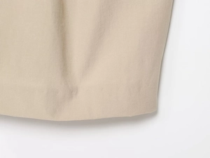 Detailed macro view of the premium beige cotton blend fabric and high-quality hem stitching