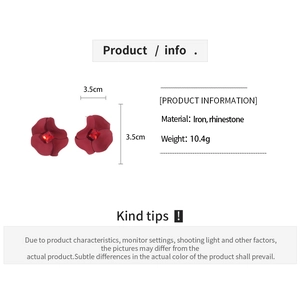 Detail view of red flower earrings with matte finish and rhinestone center with size labels