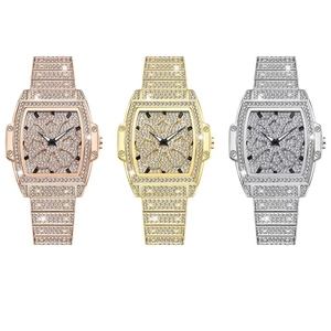 Détail macro de trois montres tonneau de luxe avec bracelets en acier pavés de diamants