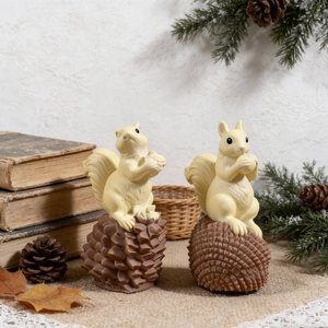 Detailed view of squirrel and pinecone resin figures in a cozy autumn tabletop setting