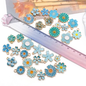 Detaillierte Makroansicht tealblauer Emaille-Blumenanhänger mit Goldrand und Strass
