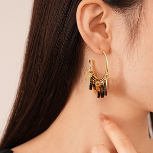 Vintage leopard resin and gold sequin hoop earrings worn by a model in a side view profile