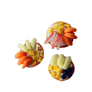 Three miniature dollhouse fruit pies including blueberry and apple on a white background