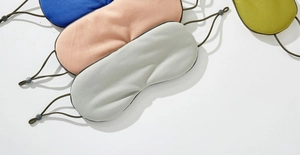 Detail showing breathable mesh texture and four color options for the sleep eye mask