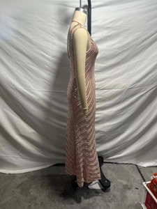 Détail d'une robe maxi à paillettes champagne avec motifs ondulés et coupe ajustée