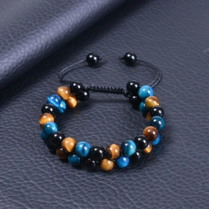 Detailed macro view of dual-layer tiger eye and obsidian beaded bracelet with adjustable cord