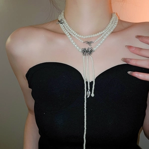 Détail du collier de perles multicouche avec pendentif ange argenté sur un mannequin