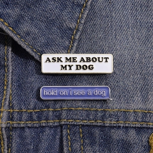 Creative enamel dog lover lapel pins set with text on blue denim fabric background