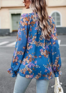 Dettaglio di elegante camicetta a fiori a maniche lunghe con polsini con volant blu