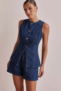 Dettaglio di un completo in denim blu scuro con gilet senza maniche bottoni e shorts