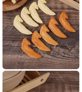 Detailed macro view of realistic faux chicken wing models on dark wood background