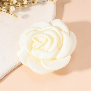 Close-up of elegant white fabric rose brooch with detailed layers and textile texture