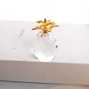 Macro detail of faceted crystal pineapple ornament with decorative golden metal leaves