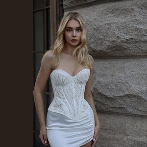 Detail shot of the white lace embroidery and boned corset structure on the top