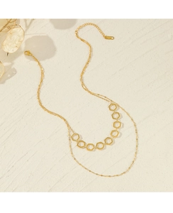 Detail of gold-plated double-layer necklace featuring geometric hexagonal charms and lobster clasp