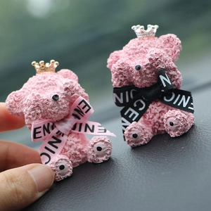 Close-up of pink textured teddy bear car air vent clip decorations with gold crowns