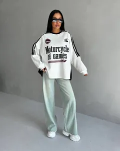 Detail shot of light gray oversized sweatshirt featuring varsity stripes and black graphic print