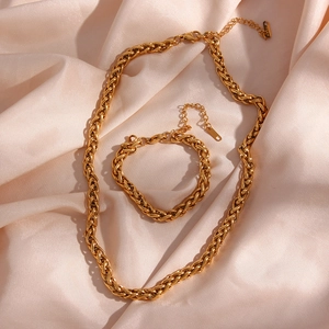 Macro detail of 6mm 18K gold plated wheat chain necklace and bracelet set on silk