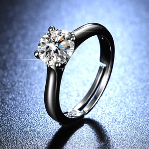 Macro detail of a one carat moissanite ring with a classic four-prong setting in black finish