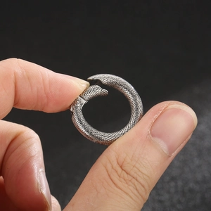Vintage silver snake ring with detailed scale textures shown on hand in dark setting