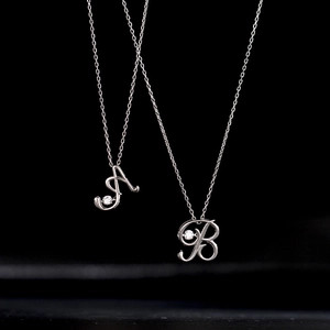 Elegant 925 silver necklace with sparkling A and B letter pendants on black background