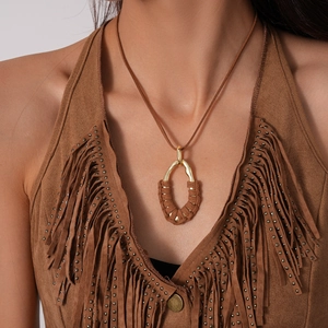 Close-up of bohemian geometric pendant with brown cord wrap on a model