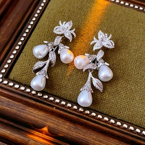 Vue détaillée de boucles d'oreilles fleurs en zircon avec trois perles en goutte