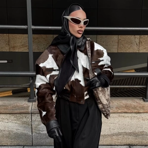 Women's cow print faux fur jacket with leather patchwork in a street style look