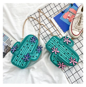 Detail of green cactus cross body bag with 3D floral accents and gold chain strap