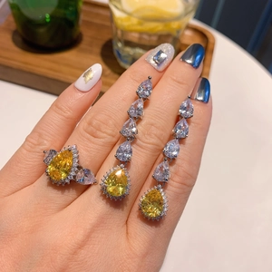 Macro shot of a pear-cut yellow diamond jewelry set featuring ring and drop earrings