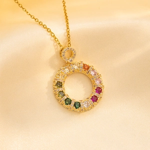 Golden titanium steel donut necklace with colorful crystals on beige silk background